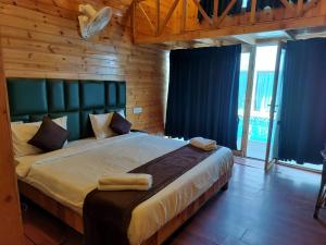 a bedroom with a large bed with blue curtains at Bay View Resort in Anjuna +17 photos