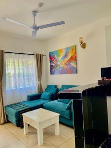 a living room with a couch and a piano at Magenta Apartment in Diani Beach