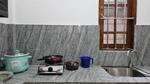 a kitchen counter with a stove and a toaster at Shan Villa Dambulla in Dambulla