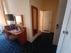a hotel room with a desk and a mirror at ZM 22, King Room doubleBed in Leverkusen