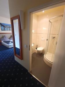 a bathroom with a shower and a toilet in a room at ZM 22, King Room doubleBed in Leverkusen