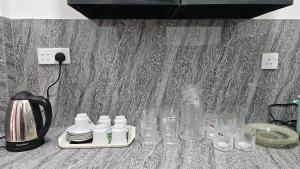 a table with glasses and a coffee maker and a kettle at Shan Villa Dambulla in Dambulla