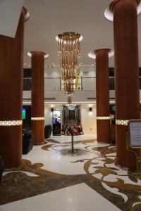 a lobby with a large chandelier in a hotel at Coral Hotel Karbala in Karbala