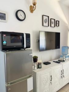 a kitchen with a microwave on top of a refrigerator at Magenta Apartment in Diani Beach