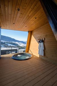 a sauna with a large tub in a wooden ceiling at Emshir Villas in Krasnik