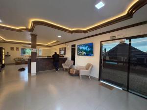 a man standing in a room with a large window at Plumas hotel in Tucuma