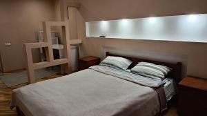 a bedroom with a bed with a large white headboard at Home for you in Ternopil