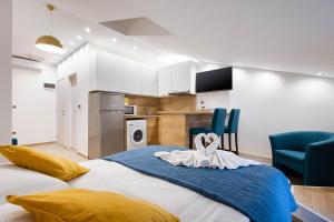 a bedroom with a large bed with two blue chairs at Apartments Pomerio Rijeka East in Rijeka