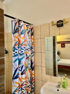 a bathroom with a sink and a shower curtain at Magenta Apartment in Diani Beach +15 photos