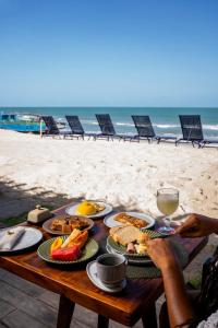 a table with plates of food on the beach at Villa Água de Côco Preá in Prea