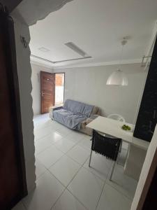 a living room with a table and a couch at Apto Tranquilo próx ao Litoral Sul Wi-Fi in João Pessoa