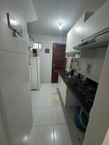 a small kitchen with a sink and a refrigerator at Apto Tranquilo próx ao Litoral Sul Wi-Fi in João Pessoa