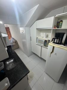a small kitchen with a refrigerator and a microwave at Apto Tranquilo próx ao Litoral Sul Wi-Fi in João Pessoa