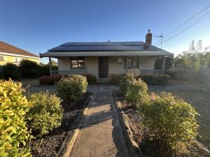 a house with a solar roof on top of it at Cosy Heritage Cottage in Ararat