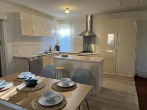 a kitchen with a table and chairs and a stove at Cosy Heritage Cottage in Ararat