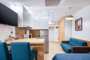 a kitchen with blue chairs and a kitchen with white cabinets at Apartments Pomerio Rijeka East in Rijeka +30 photos