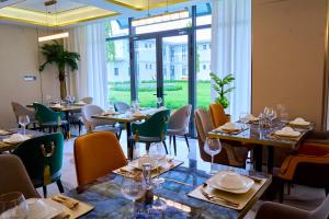 a restaurant with tables and chairs and a large window at Dembesh Hotel Juba in Juba