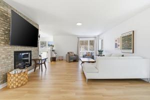 a living room with a white couch and a fireplace at Spa Pool Table - Luxurious pool - Chalet Houefifa in Saint Come +42 photos