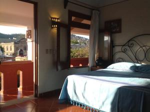 a bedroom with a bed and a window with a view at Hotel Maela in Oaxaca City