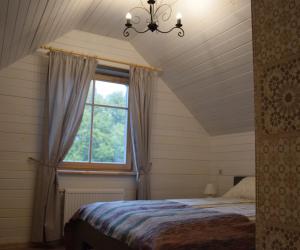 ein Schlafzimmer mit einem Bett und einem Fenster in der Unterkunft Stikāni in Bernāni