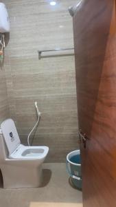 a bathroom with a white toilet in a room at Swapnainn in Ongole