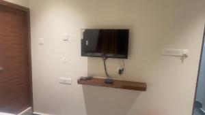 a flat screen tv hanging on a wall at Swapnainn in Ongole