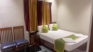 a small bedroom with two beds and a window at Swapnainn in Ongole