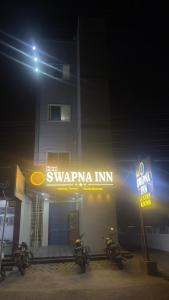 a group of motorcycles parked in front of a building at night at Swapnainn in Ongole +12 photos