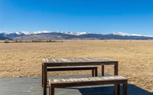 a wooden table and bench on a boardwalk in the desert at Luxury Off-Grid Cabin with Stargazing Deck & Views in Fairplay