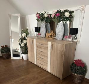 a dresser with vases on top of it with a mirror at APARTMENT ZVONÁRSKA with FREE PARKING in Košice