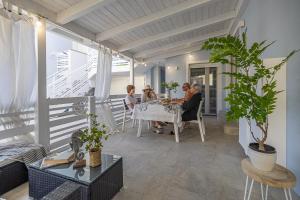 a group of people sitting at a table on a balcony at Villetta with private jacuzzi in San Mauro a Mare