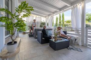 a group of people sitting on the porch of a house at Villetta with private jacuzzi in San Mauro a Mare