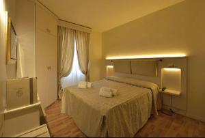 a bedroom with a bed with two towels on it at Hotel Arcobaleno in Siena +84 photos