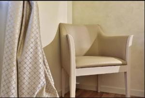 a white chair sitting next to a window at Hotel Arcobaleno in Siena