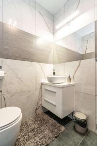 a white bathroom with a sink and a toilet at Tarasówka u Zająca in Zakopane +64 photos