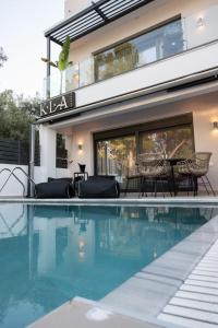 a swimming pool in front of a house at KLA Luxury Boutique Villa with Pool & Jacuzzi by WESTBOOKING GR in Nikiana