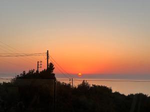 a sunset over the ocean with the sun in the sky at Casa del Rosa in Kafr ‘Ubaydā