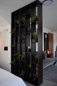 a black book shelf with potted plants in a bedroom at aifoS in Xanthi