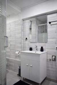 a white bathroom with a sink and a mirror at aifoS in Xanthi +24 photos