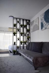 a living room with a couch and a shelf with plants at aifoS in Xanthi