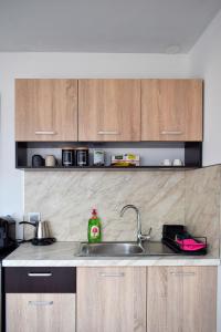 a kitchen with a sink and wooden cabinets at aifoS in Xanthi