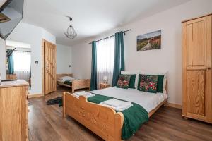 a bedroom with a bed with green and white sheets at Tarasówka u Zająca in Zakopane