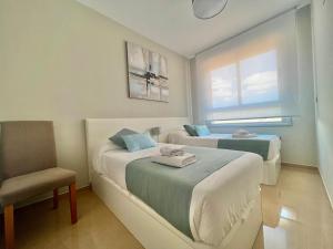 a hotel room with two beds and a chair at CJ186 - Ciudad Jardin I, Prime - ServHouse in El Borseral +32 photos