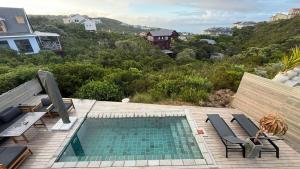 a swimming pool on top of a deck with chairs at Shade & Salt in Sedgefield