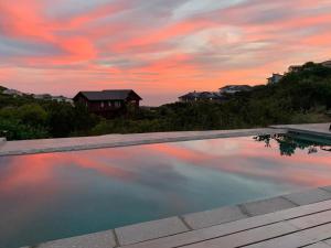 a swimming pool with a sunset in the background at Shade & Salt in Sedgefield