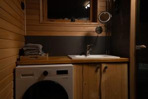 a bathroom with a sink and a washing machine at Rahkis Lodge Saariselkä in Saariselka +13 photos