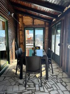a dining room with a table and chairs on a patio at Mountain houses Milovanovic in Žabljak
