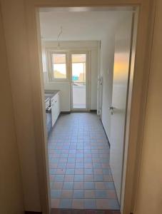 a hallway leading to a kitchen with a tile floor at Shared Apartment in central Luzern in Lucerne
