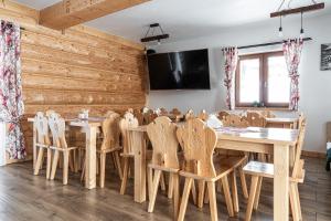 a dining room with wooden walls and tables and chairs at Tarasówka u Zająca in Zakopane