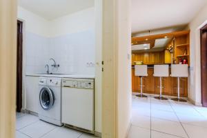 a kitchen with a washing machine and a sink at Resitour - Kamares Village in Paphos